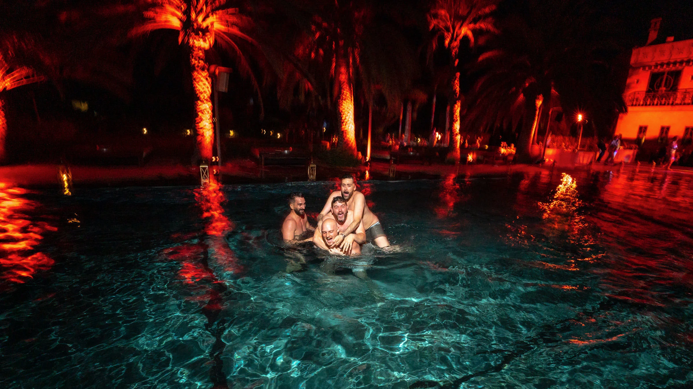 Bain nocturne dans la piscine éclairée, palmiers, Marrakech