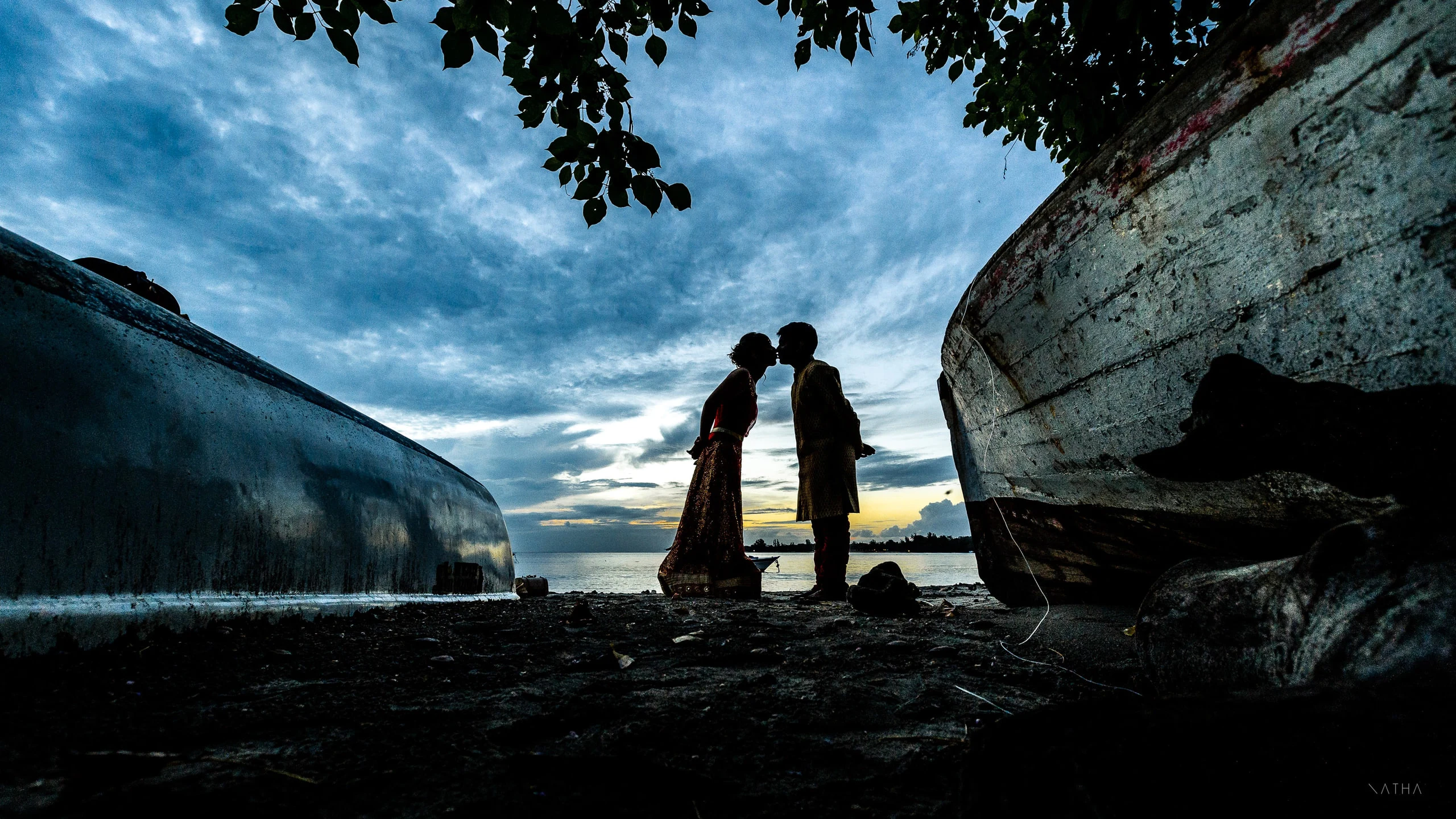 Baiser en silhouette près d’une barque au crépuscule, île Maurice