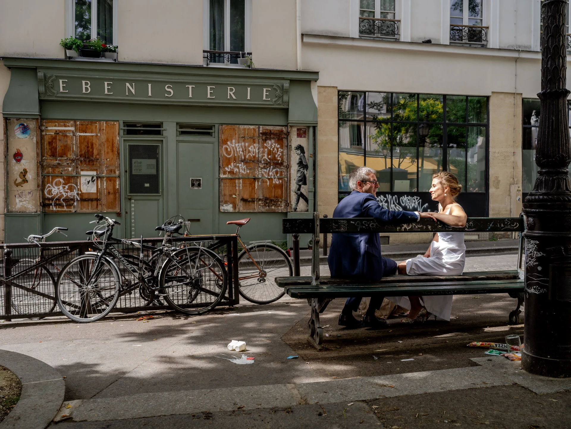 Le couple sur un banc devant une ébénisterie parisienne
