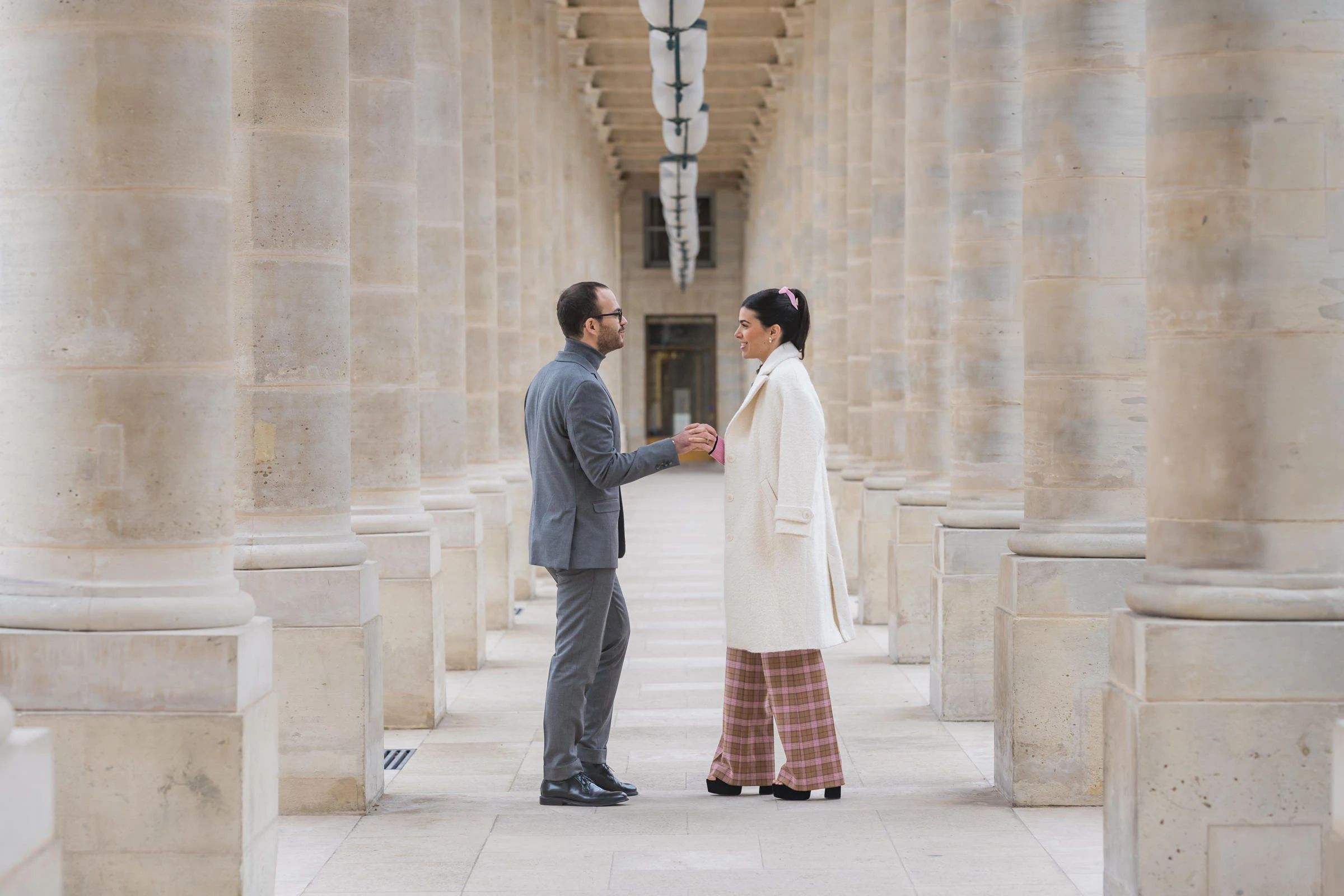 Le couple face à face sous la colonnade du Louvre, Paris
