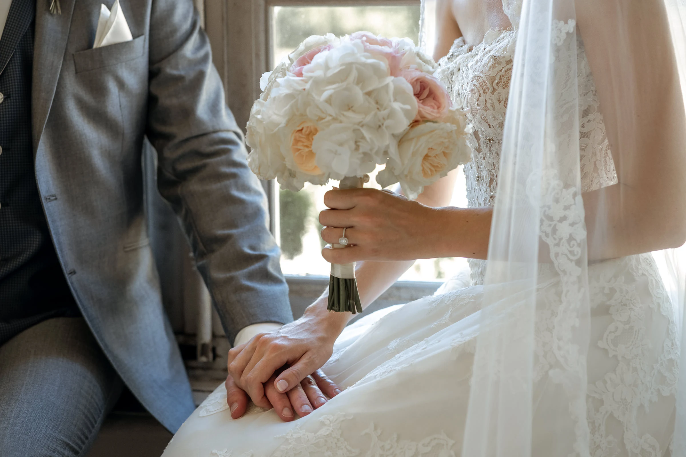 Detail of the hydrangea bouquet and the couple’s hands, château de Champlâtreux
