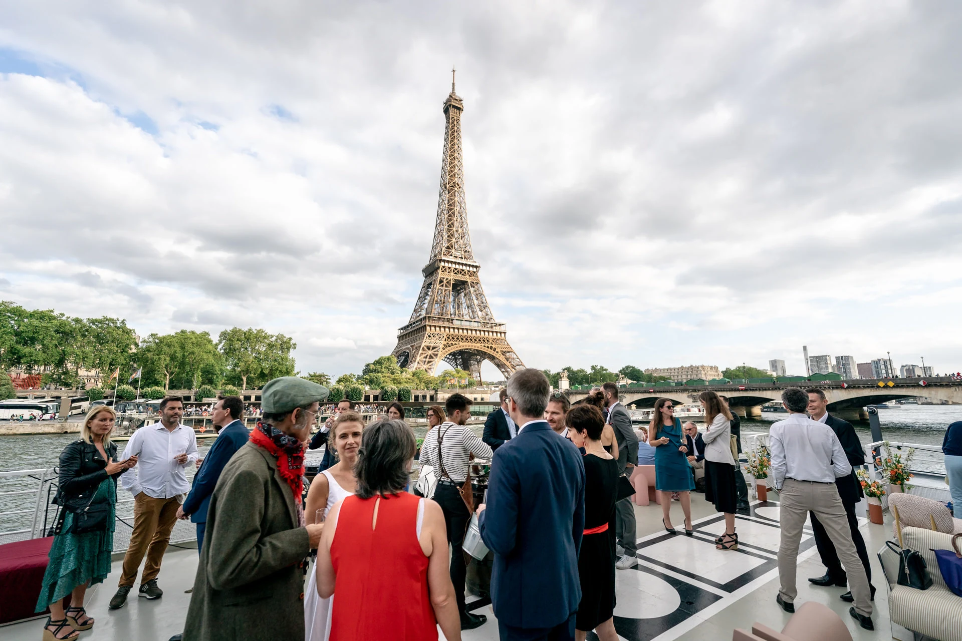Les invités sur le pont de la péniche, tour Eiffel en fond