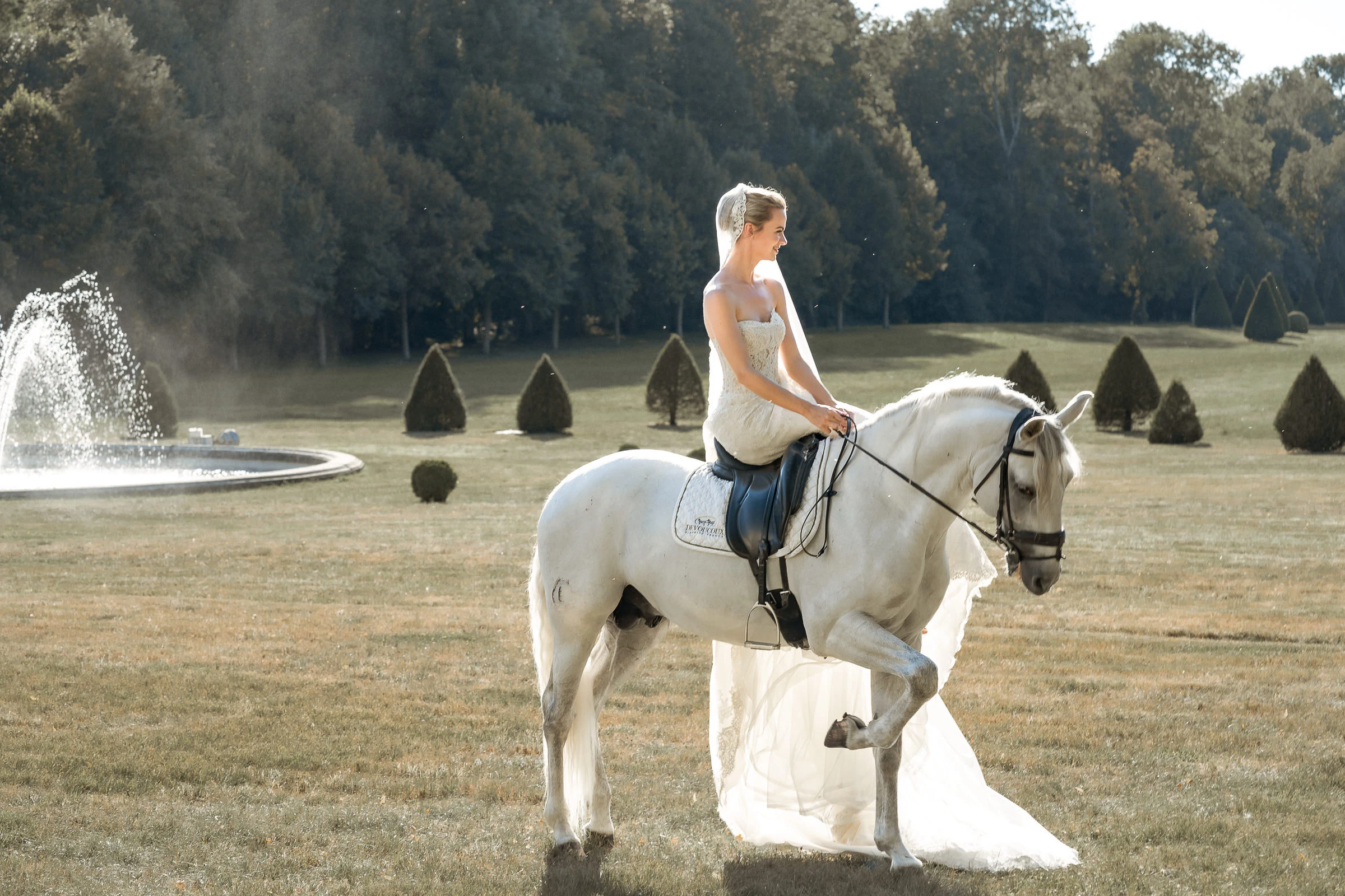 La mariée à cheval dans le parc, près de la fontaine, château de Champlâtreux