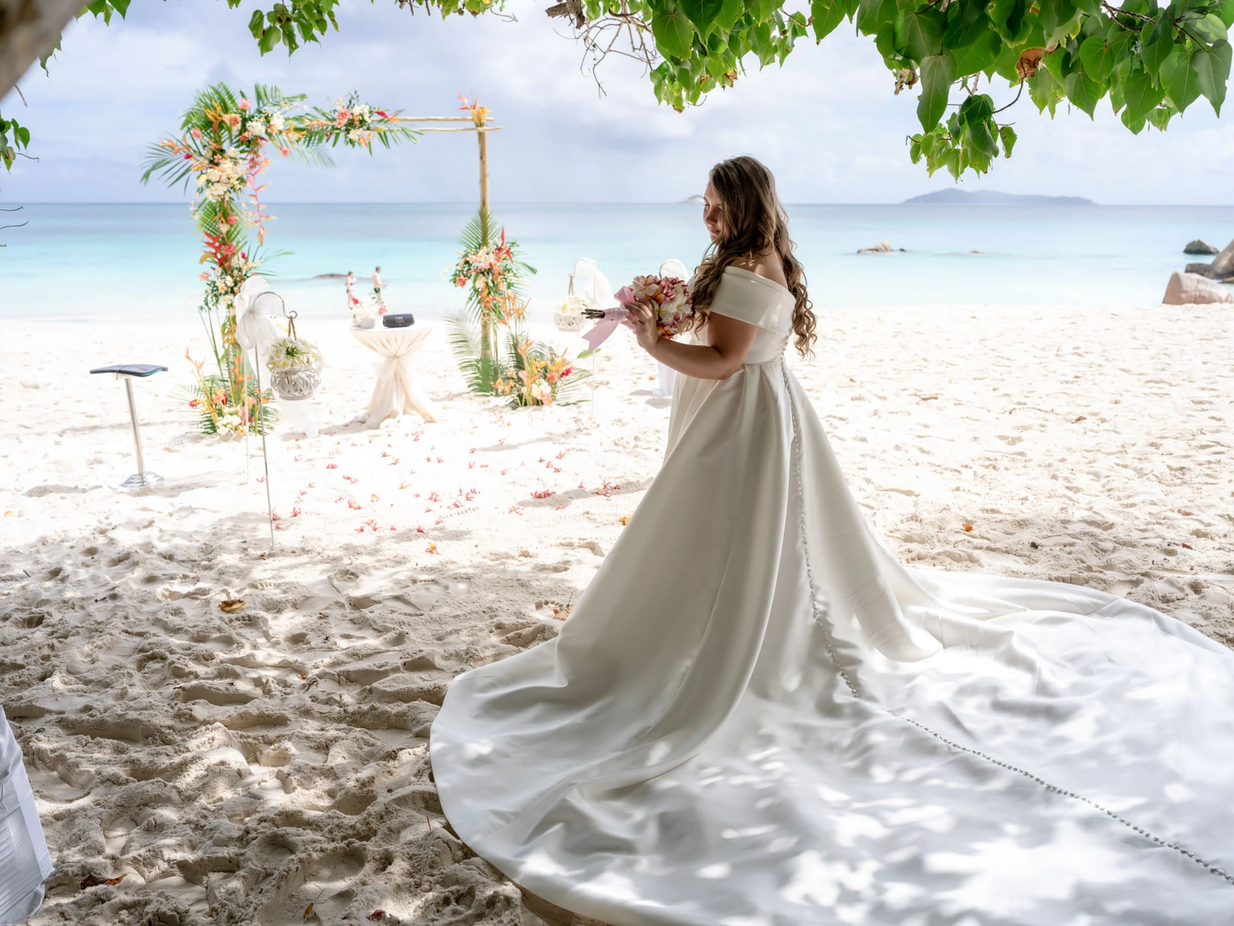 La mariée devant l’arche fleurie sur la plage, Seychelles