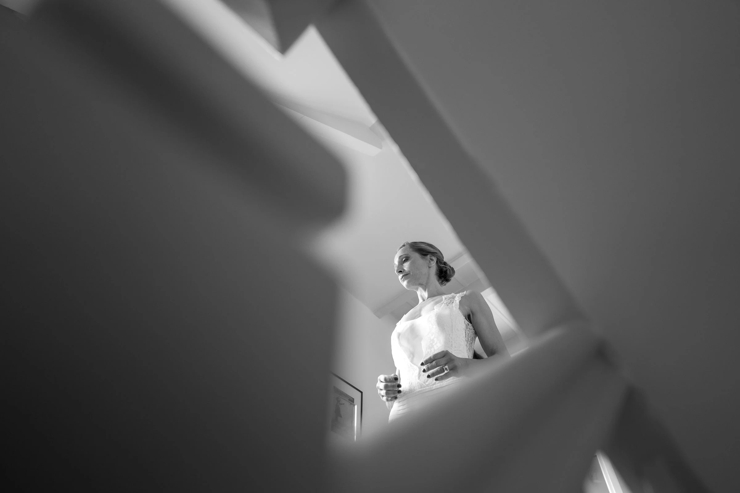 La mariée cadrée entre les barreaux de la rampe, noir et blanc