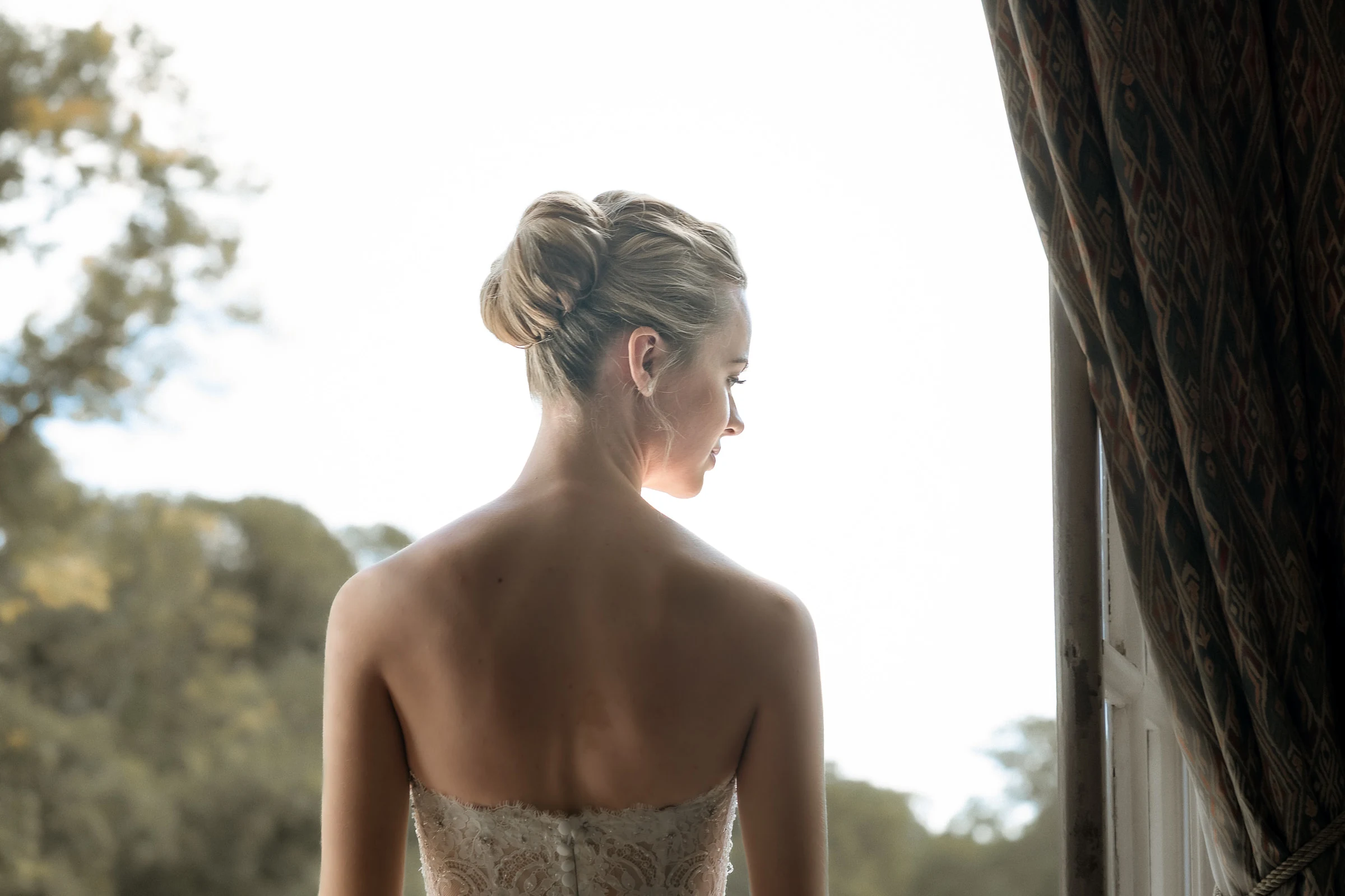 The bride from behind, facing the window open onto the park, château de Champlâtreux