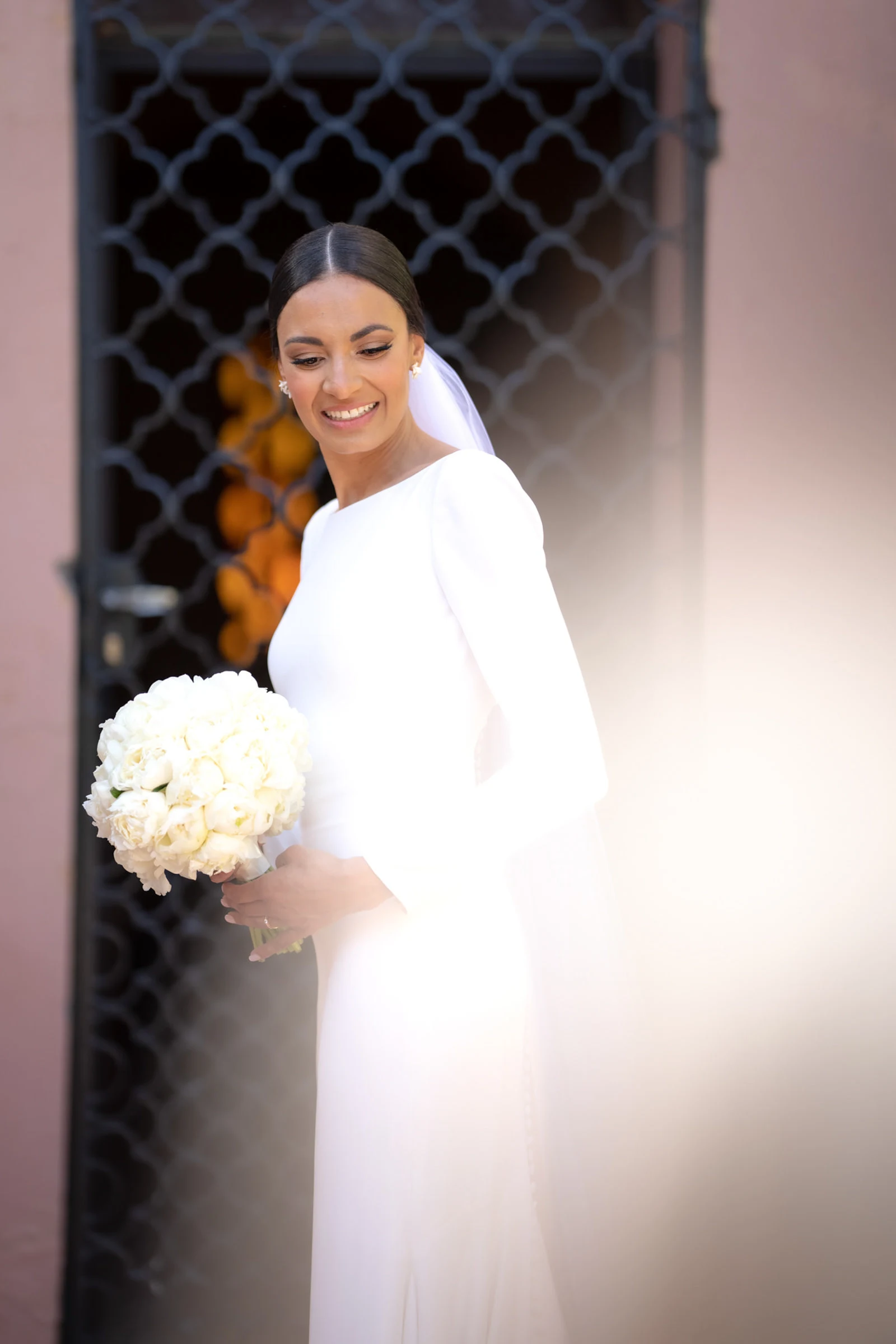 La mariée derrière un moucharabieh, bouquet blanc, Marrakech