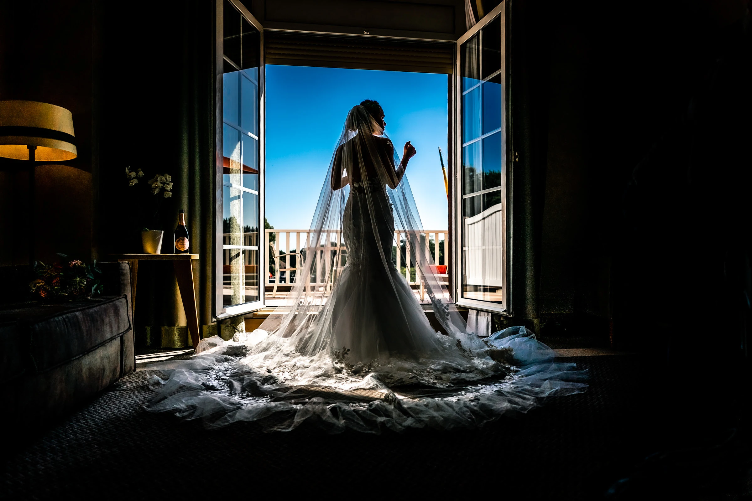La mariée en silhouette dans la porte-fenêtre ouverte sur le balcon, Hôtel Barrière Le Normandy, Deauville