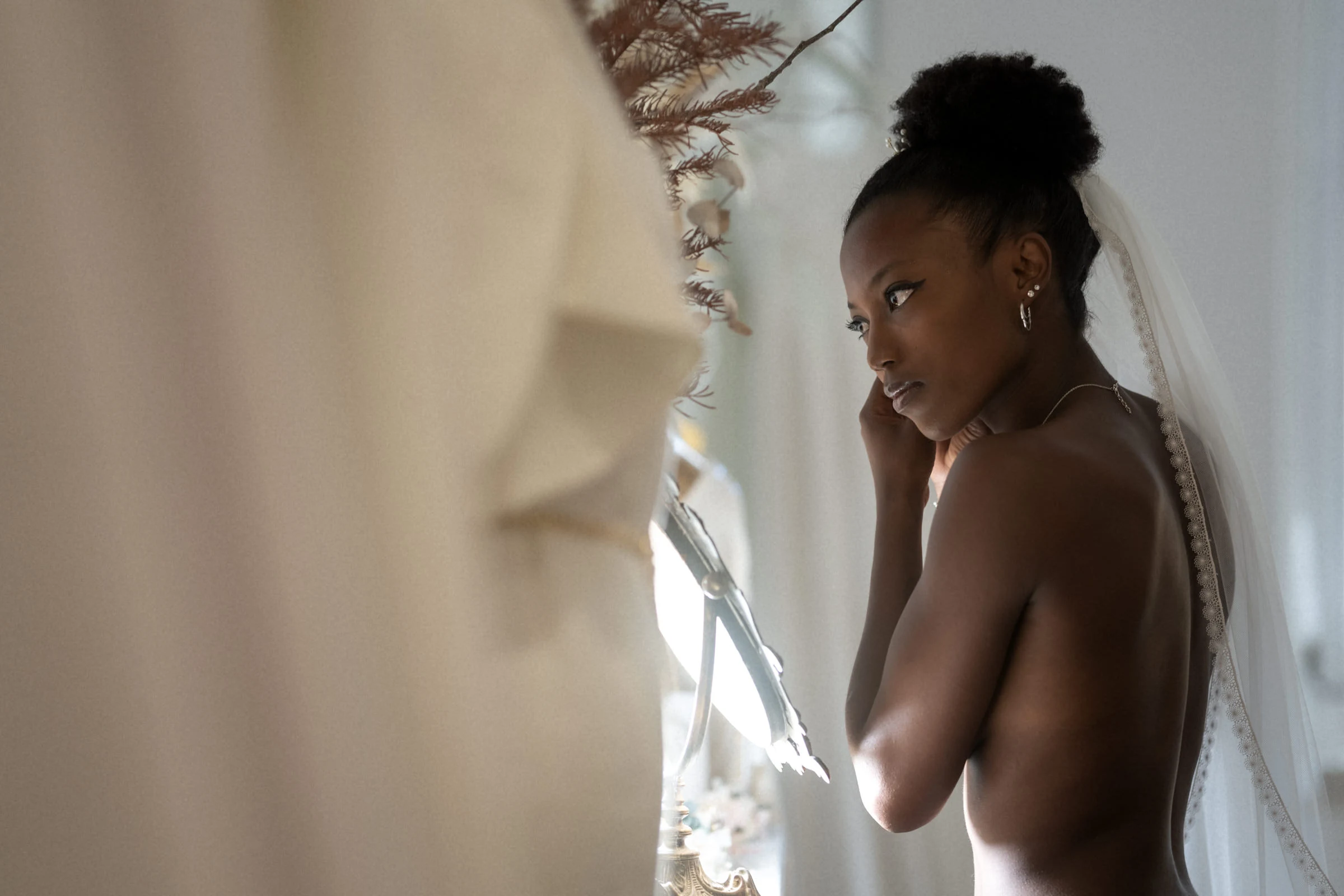The bride beneath her veil at the window during the preparations, Châteauneuf-sur-Loire