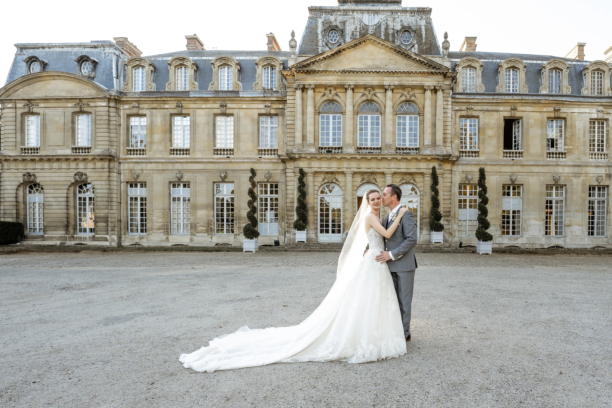 Baiser des mariés devant la façade du château de Champlâtreux