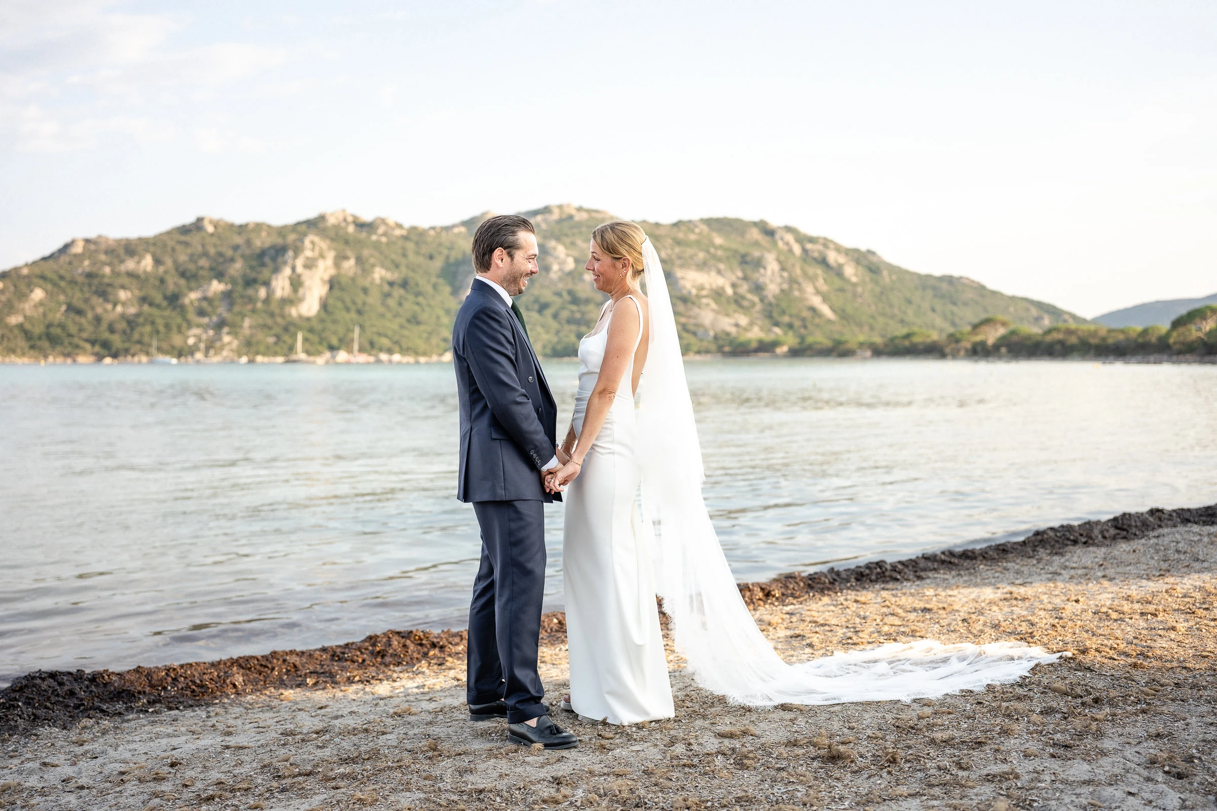 Les mariés main dans la main sur la plage de Santa Giulia