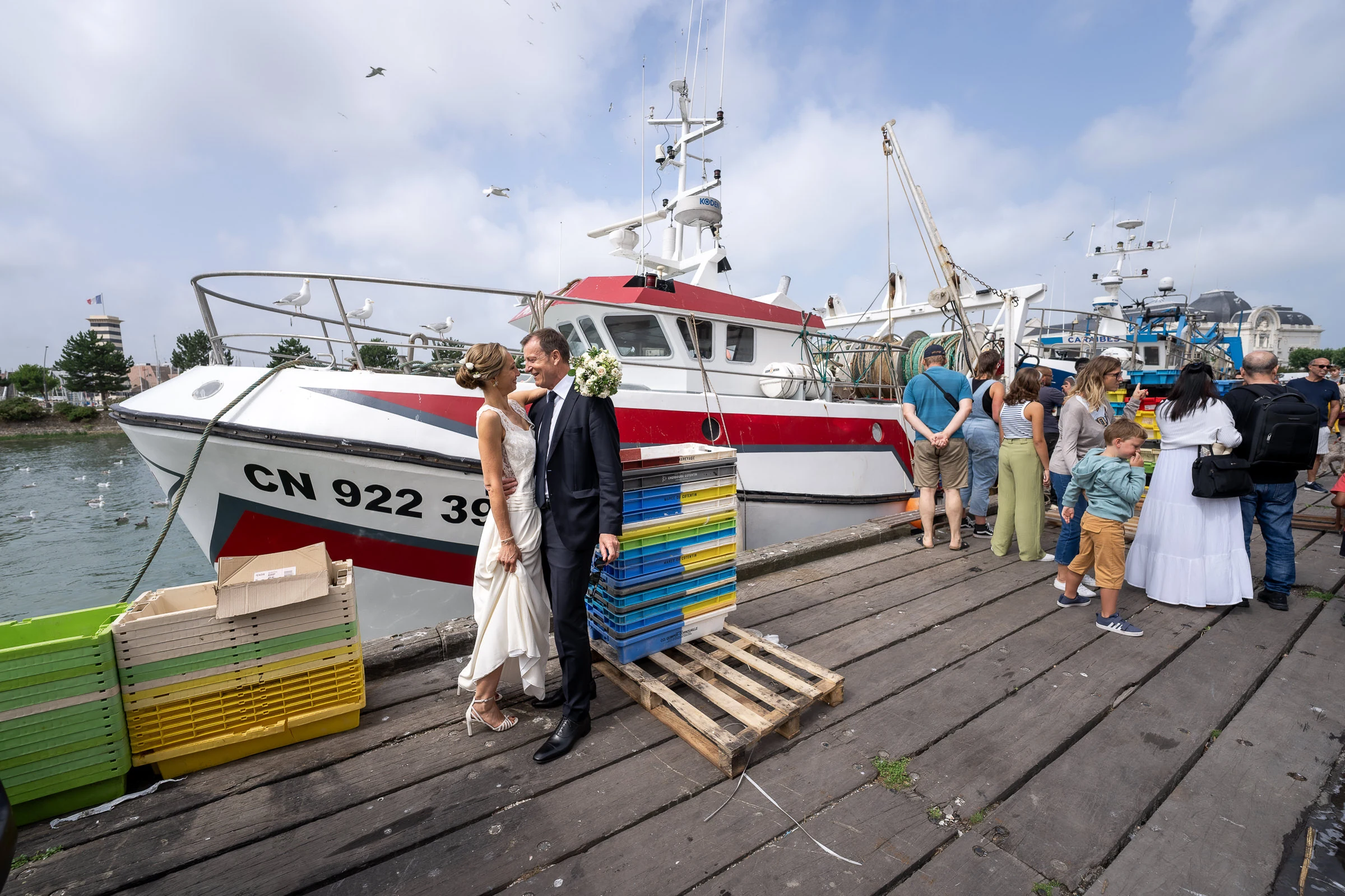 Les mariés et leurs invités sur le quai devant un bateau de pêche, Trouville