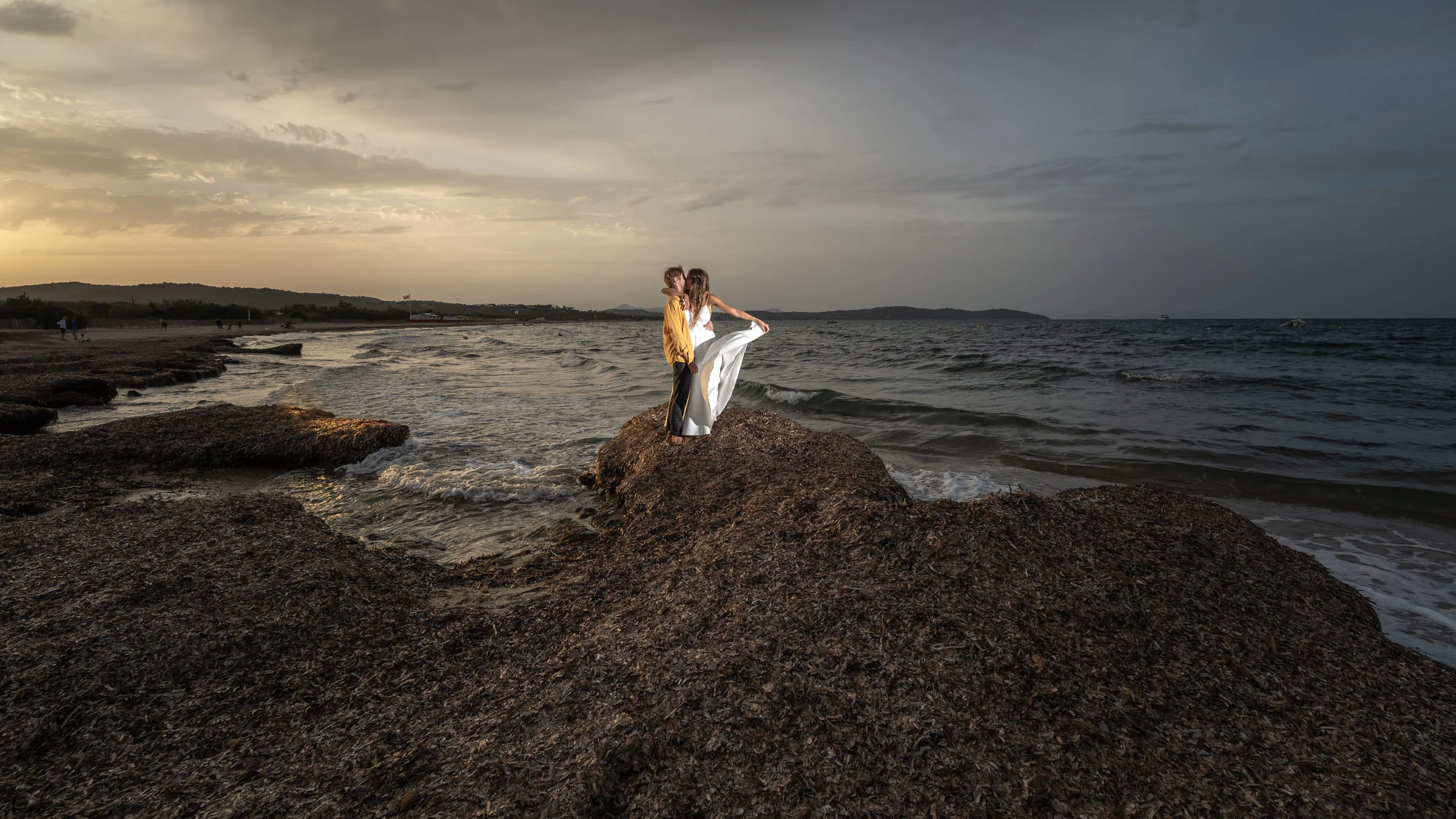 The couple on the rocks facing the sea under a storm sky, Ramatuelle beach near Saint-Tropez