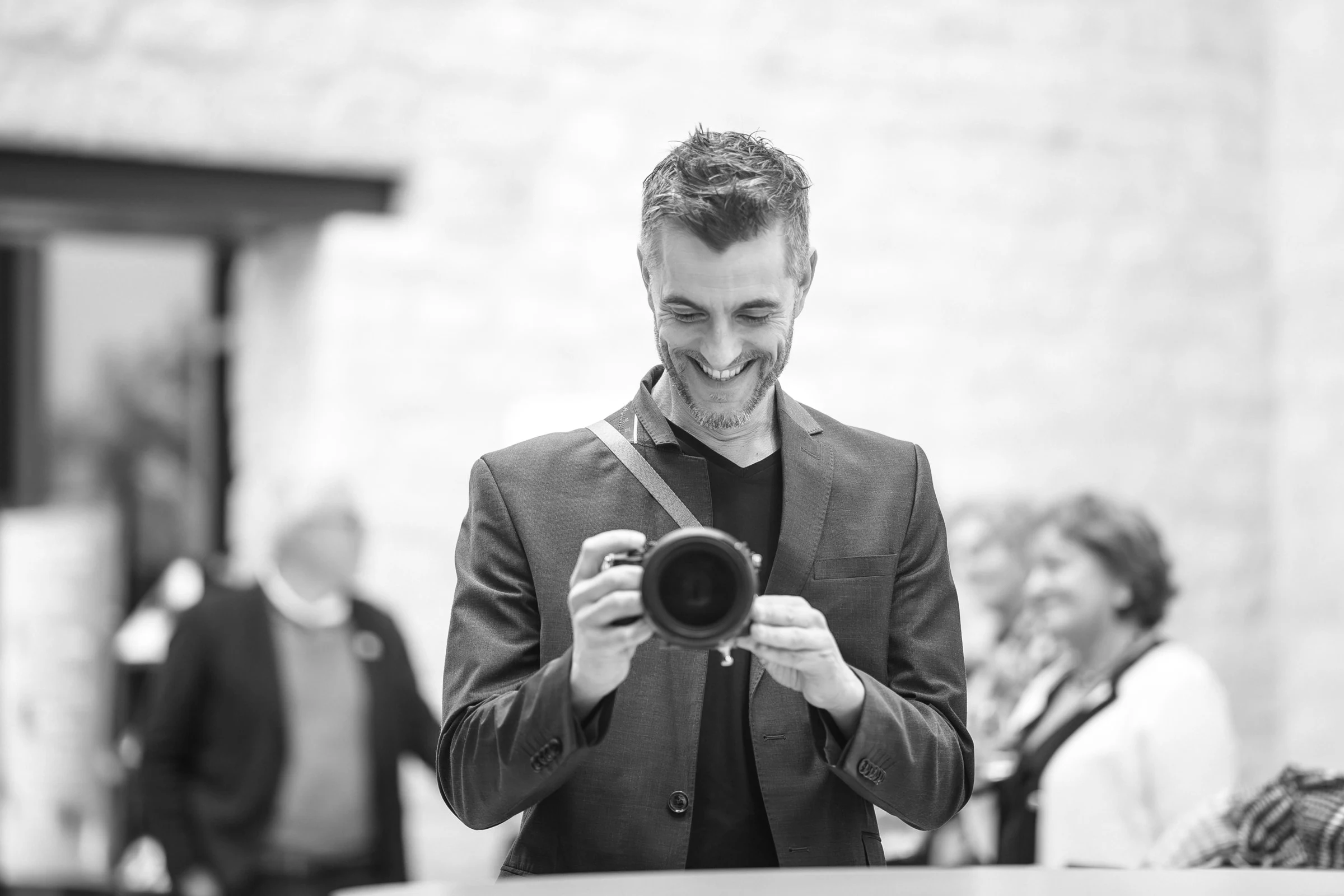 Nathanaël Charpentier laughing behind his camera during a wedding
