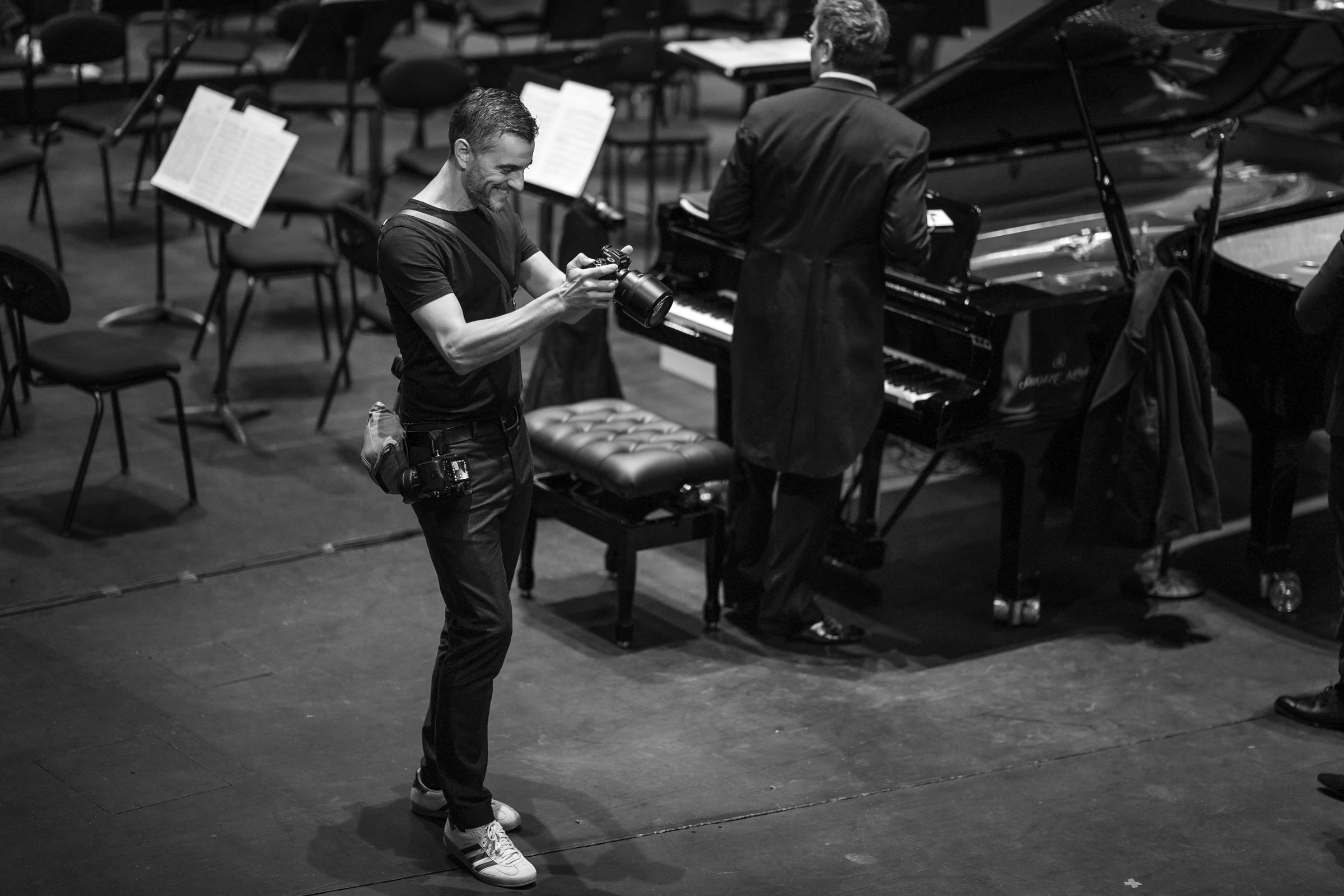 Nathanaël Charpentier photographing a pianist on stage, black and white