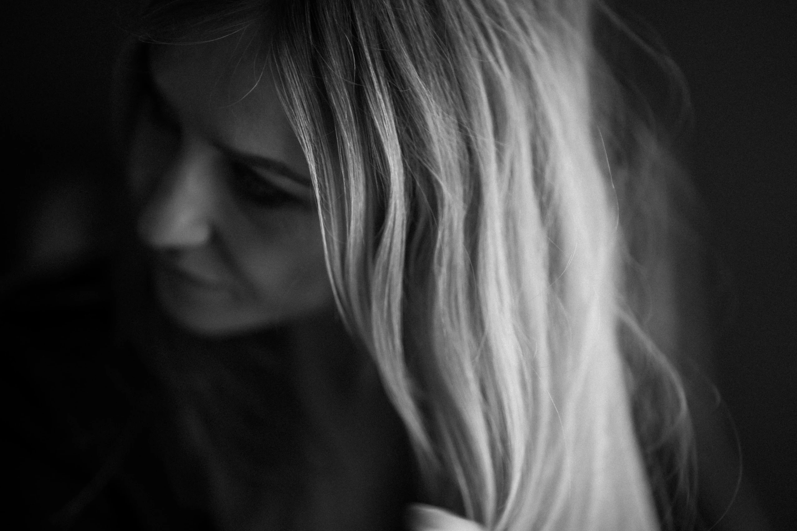 Regard baissé sous les cheveux, noir et blanc, studio