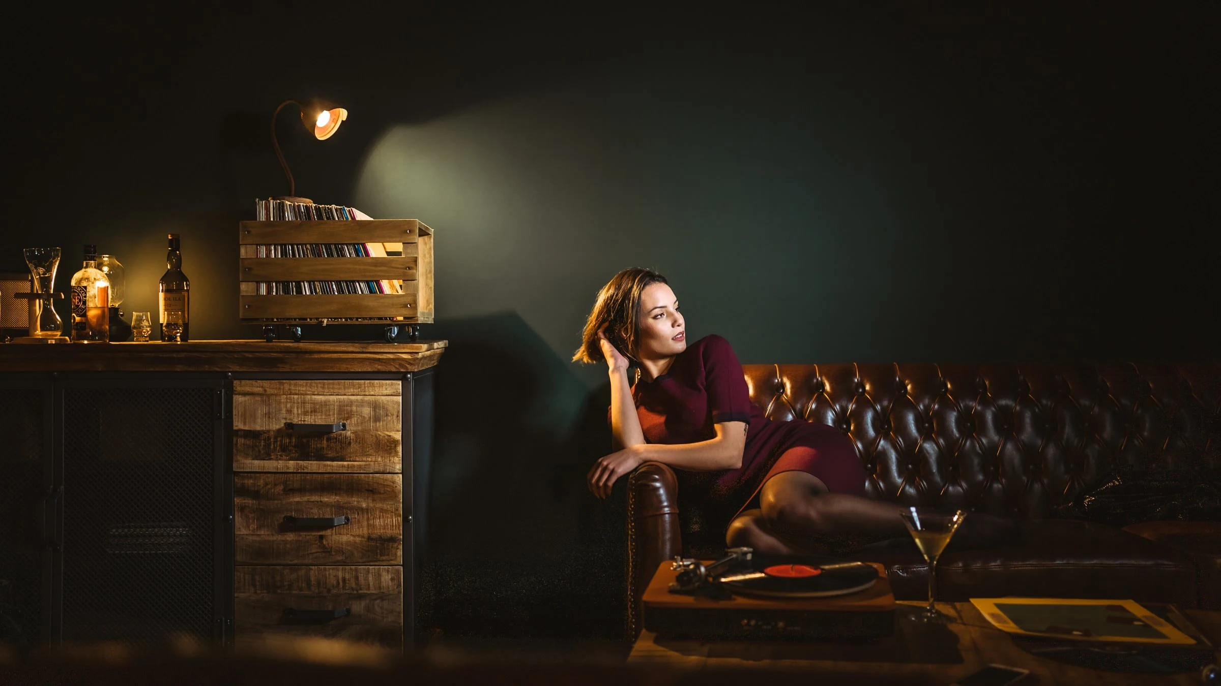 Allongée sur le chesterfield, robe bordeaux et cocktail, studio à Gien