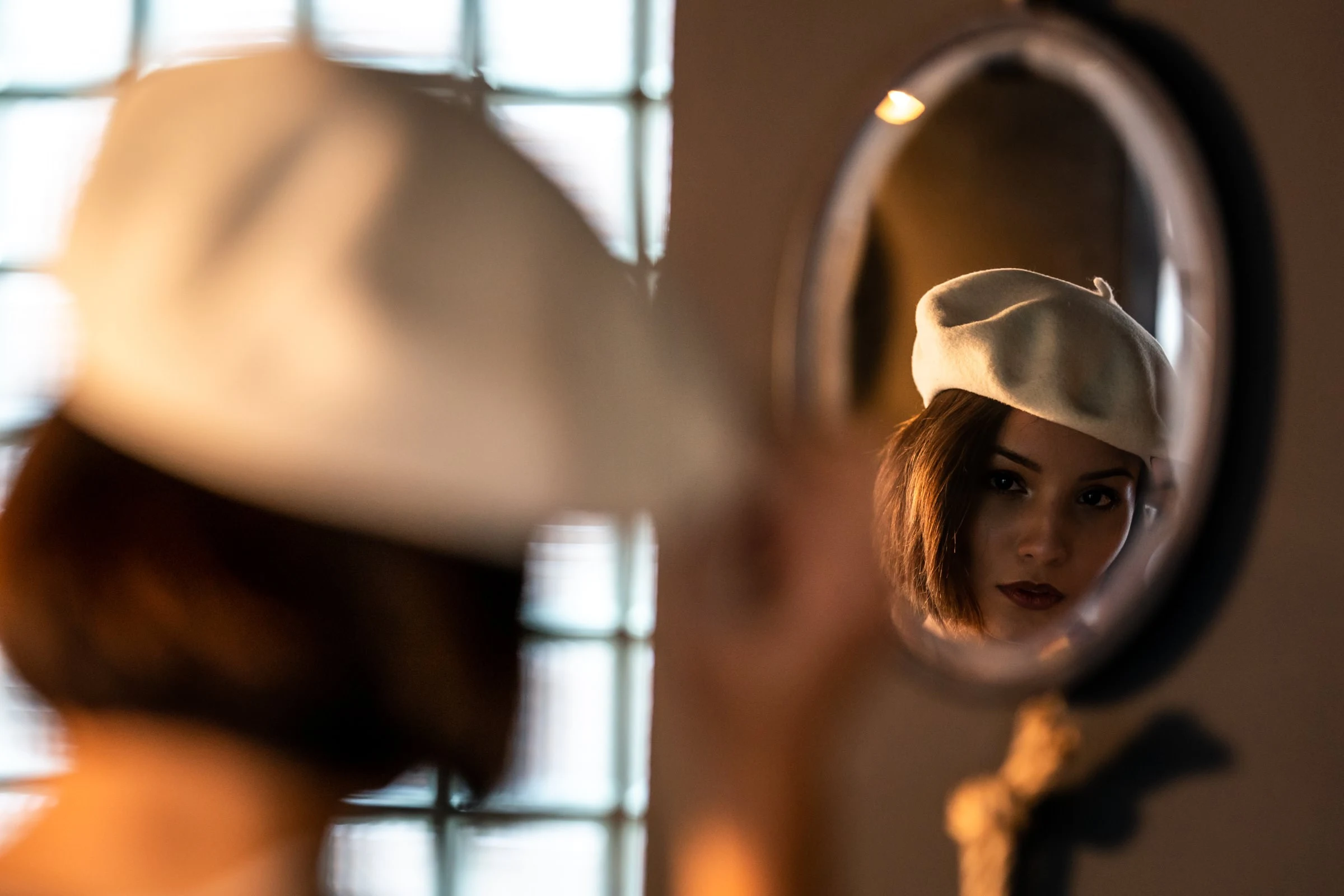 Reflet dans le miroir rond, béret et lèvres rouges, studio à Gien