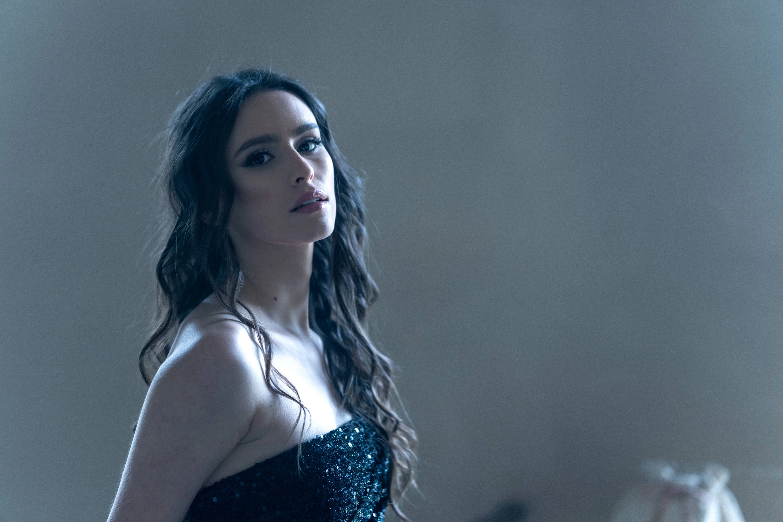 Portrait en robe à sequins dans la lumière d’une fenêtre