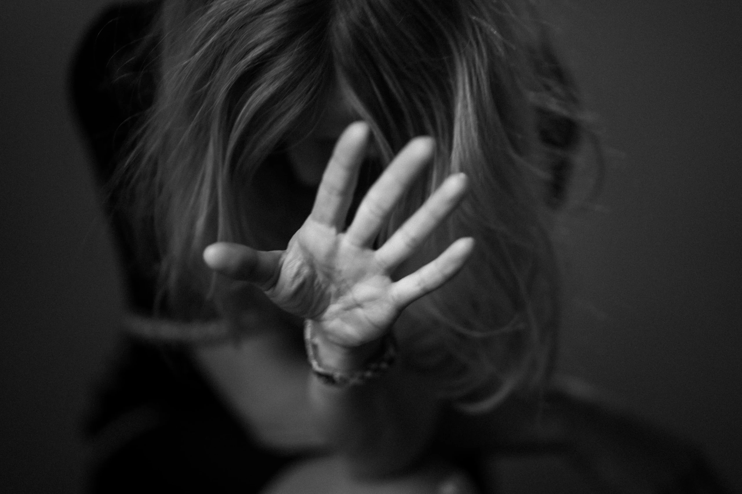 La main qui se protège : la pudeur d’une séance portrait, noir et blanc