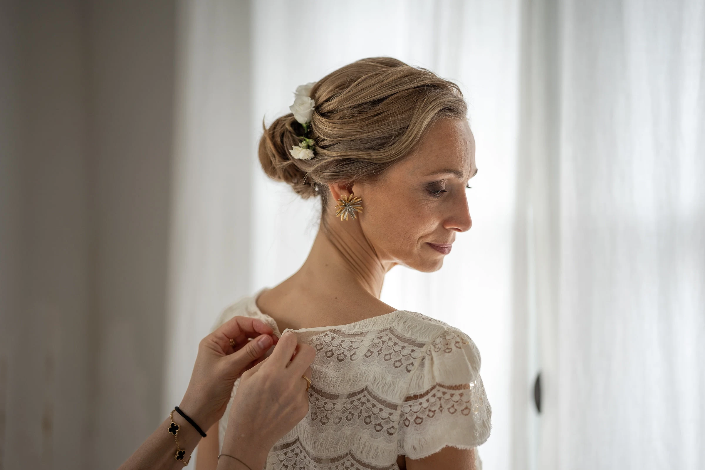 Portrait de la mariée près du voilage pendant les préparatifs