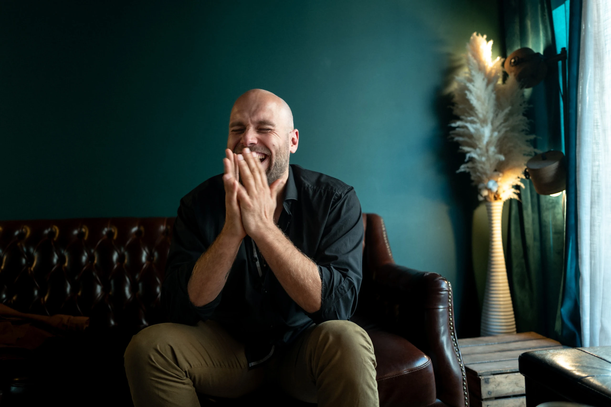 Rire sur le chesterfield, mur vert du studio