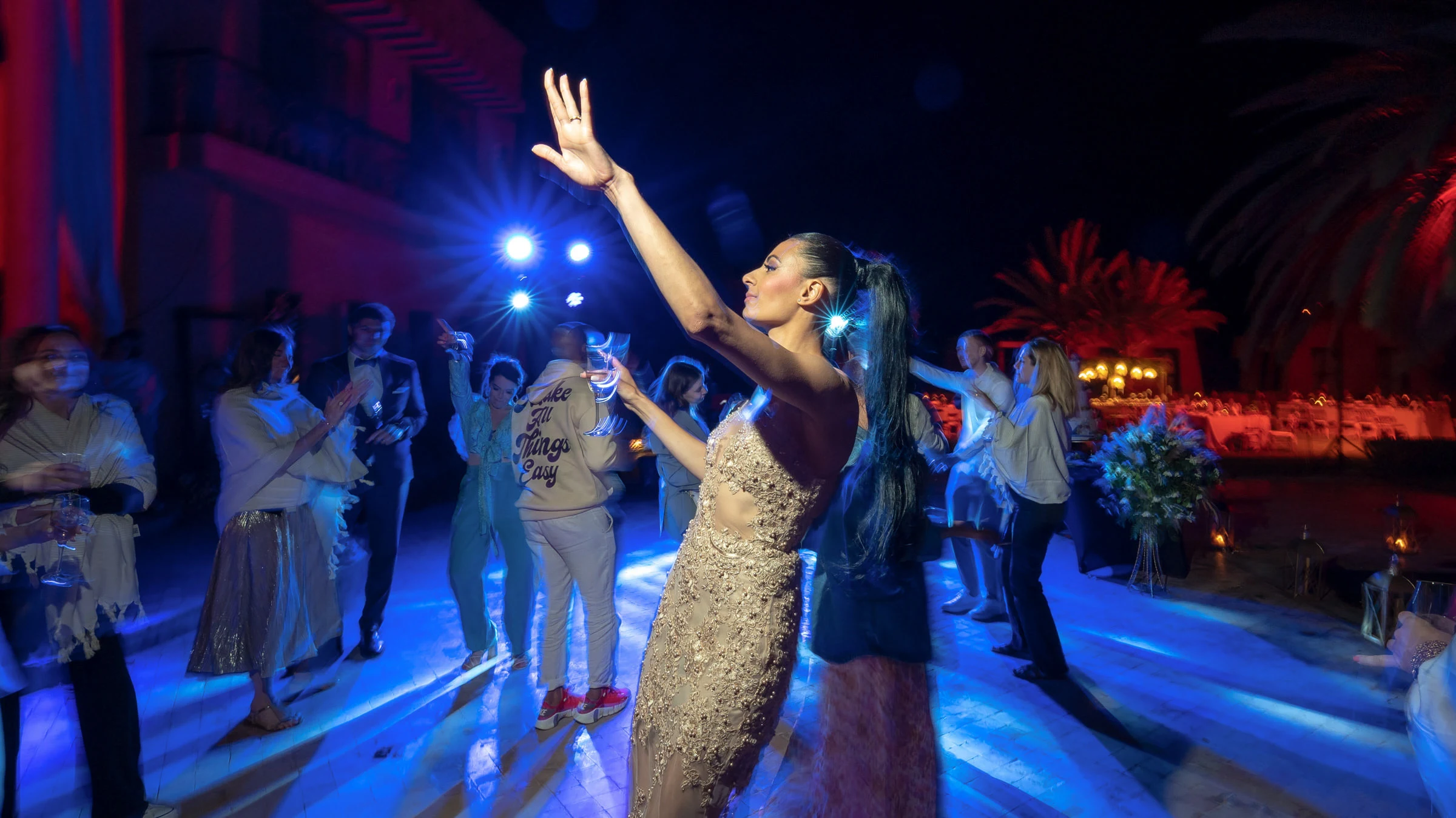 Les invités bras levés sous les lumières bleues, Marrakech