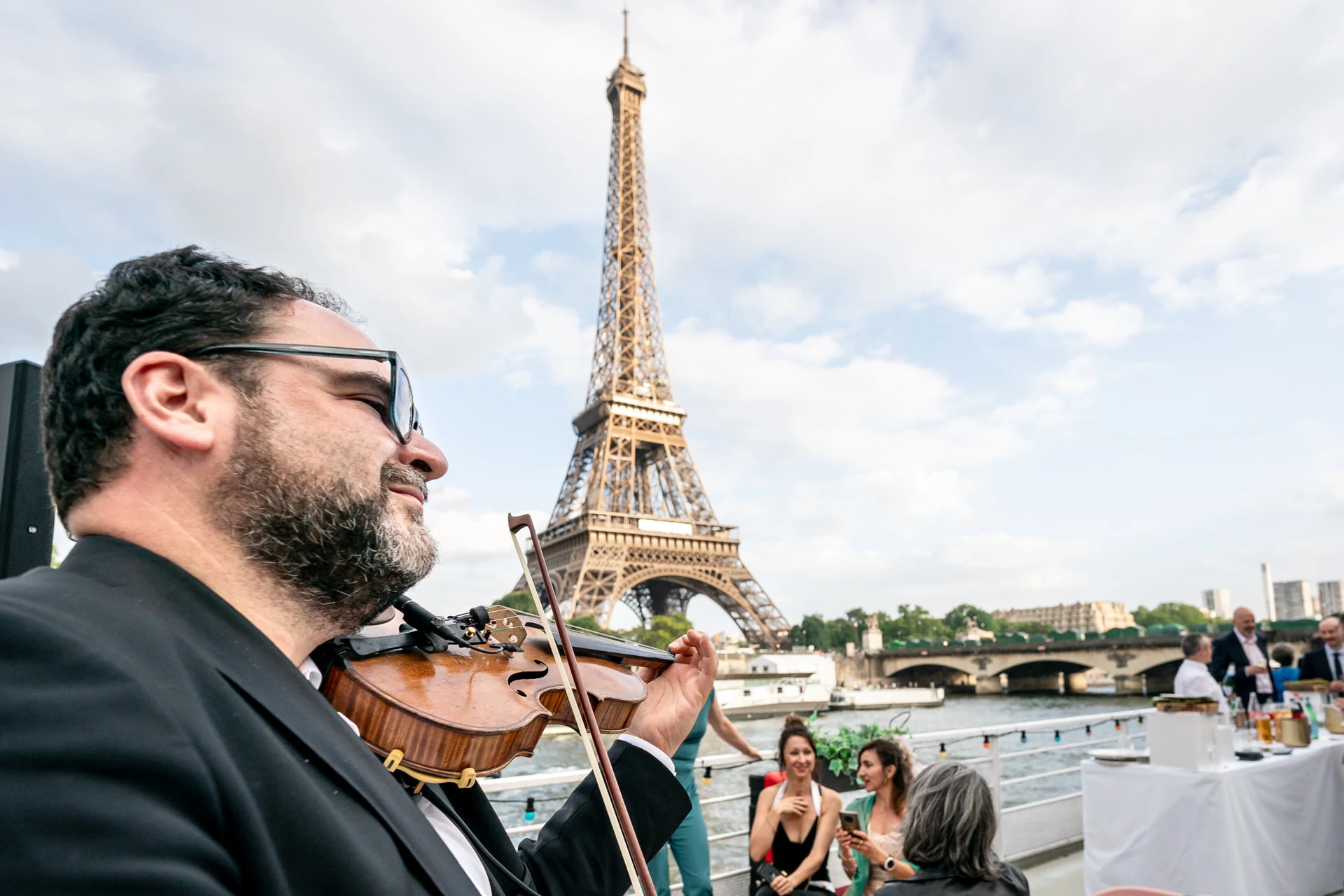 Les violonistes jouent sur la péniche face à la tour Eiffel